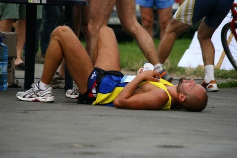  Уморен спортист лежи на земята