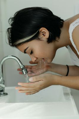  eine Frau wäscht ihr Gesicht