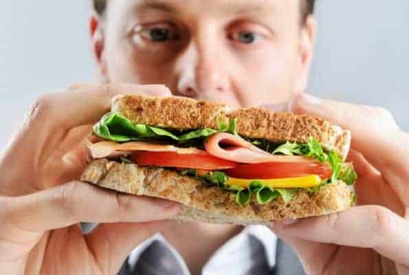  ein Mann isst ein Sandwich