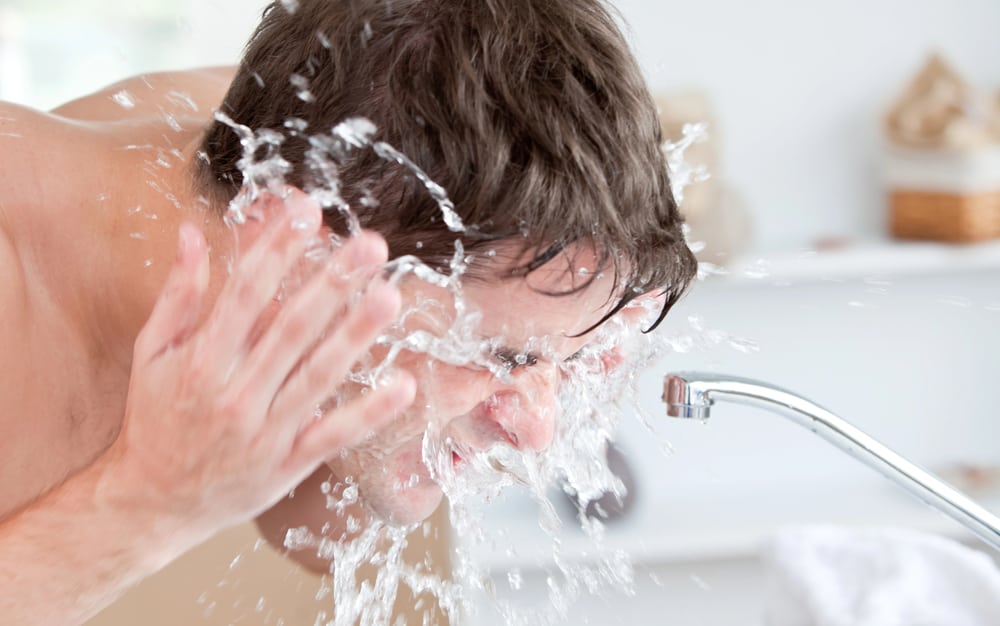  Ein Mann wäscht sein Gesicht