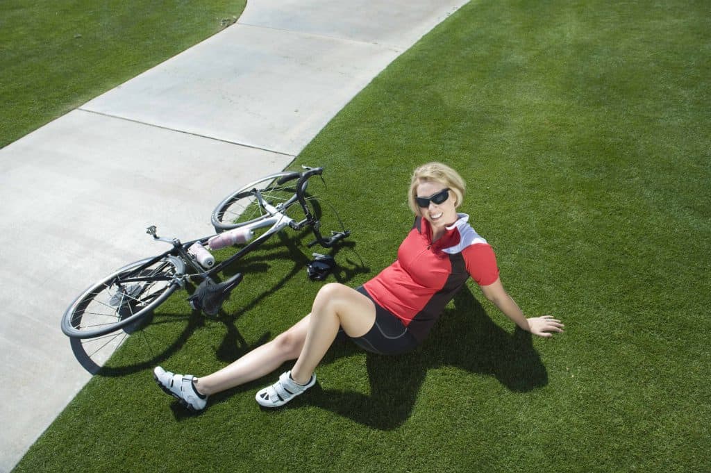  kvinde sidder ved siden af en cykel