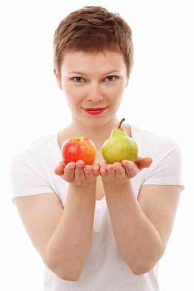  une femme garde une pomme et une poire