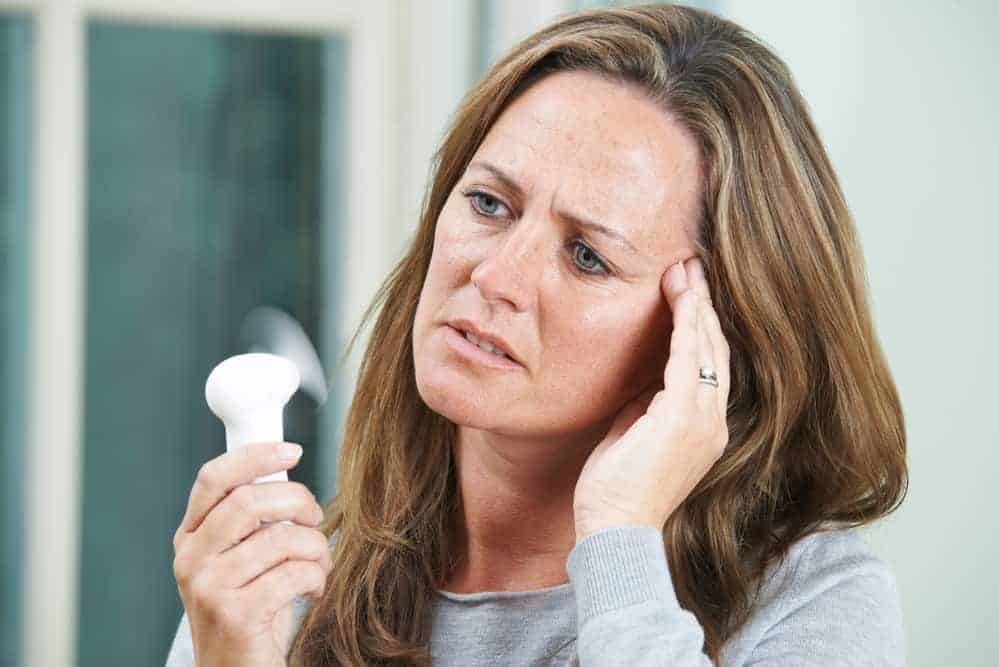  μια γυναίκα με τα συμπτώματα της εμμηνόπαυσης
