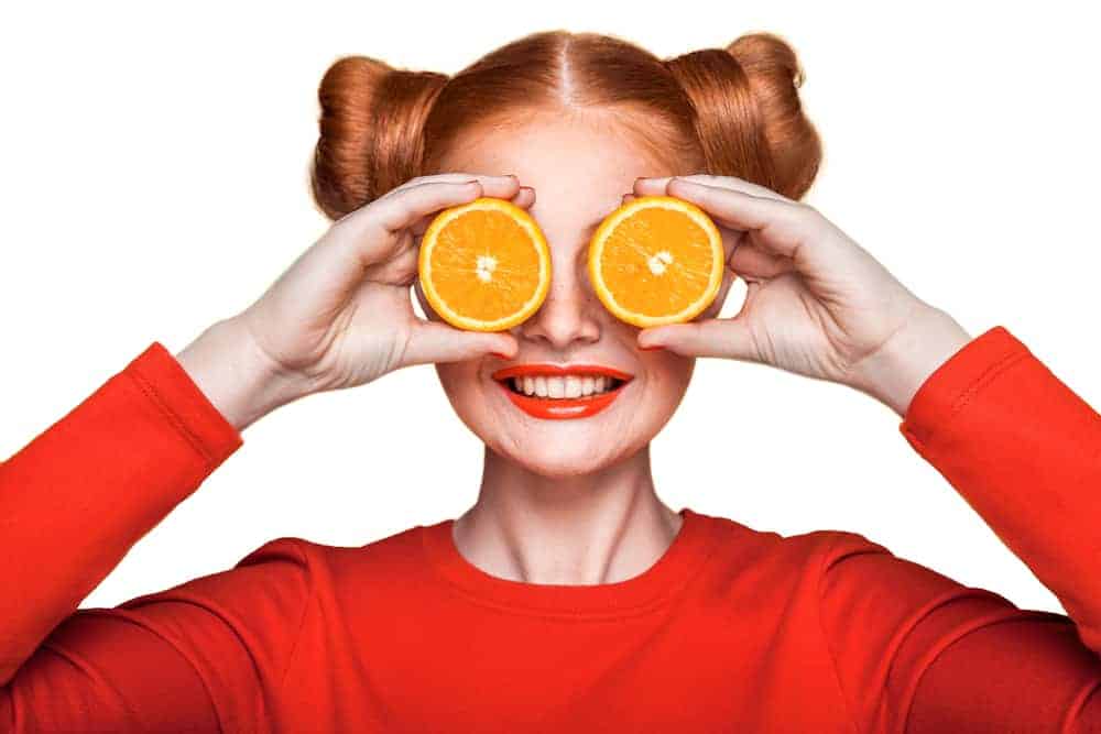  moteris su apelsinų vaisiais