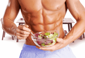  Muskuļots vīrietis ēd salātus