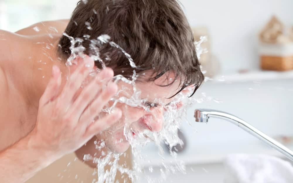  een man wast zijn gezicht