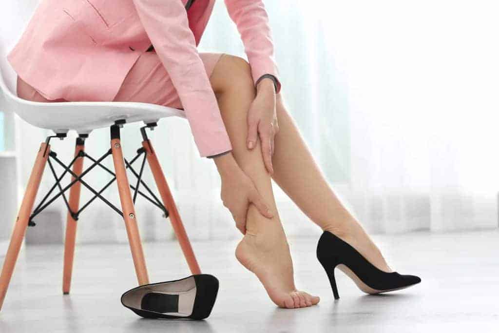  o femeie își masează piciorul