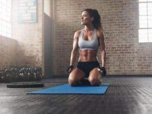  kvinna på knä på en träningsmatta